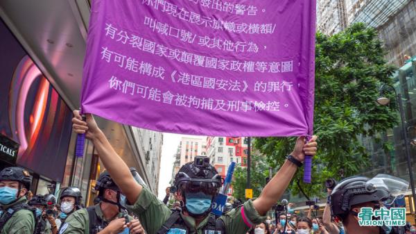 2020年《港区国安法》生效，港警高举举紫旗警告香港市民噤声。（图片来源：庞大卫/看中国）