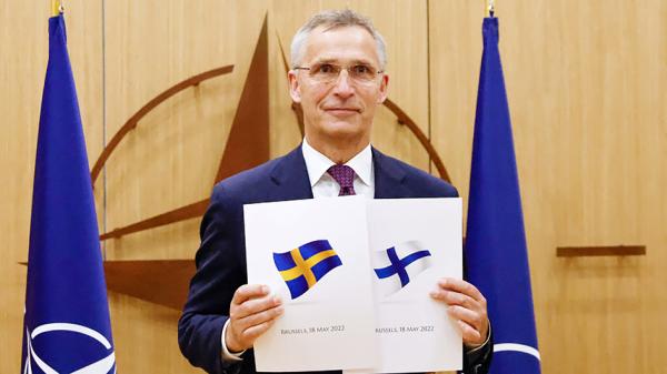 5月18日，在瑞典和芬兰申请加入联盟的仪式上，北约秘书长斯托尔滕贝格与两国提交的申请文件合影留念。（JOHANNA GERON/POOL/AFP via Getty Images）