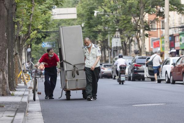 2022年6月6日，在上海一条街道上，人们在运输冰箱。（Hugo Hu/Getty Images）