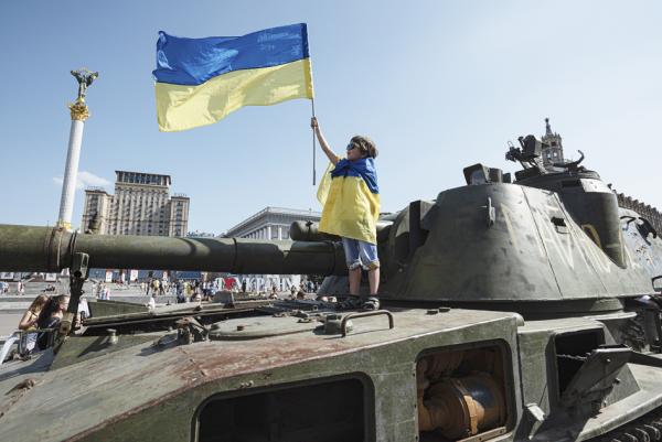 乌克兰首都基辅市中心，一个小男孩身裹和手持国旗站在一辆被缴获的俄罗斯军车上。（Alexey Furman/Getty Images）