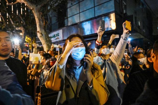 2022年11月27日，人们聚集在上海的街道上，抗议当局的清零政策。（HECTOR RETAMAL/AFP via Getty Images）