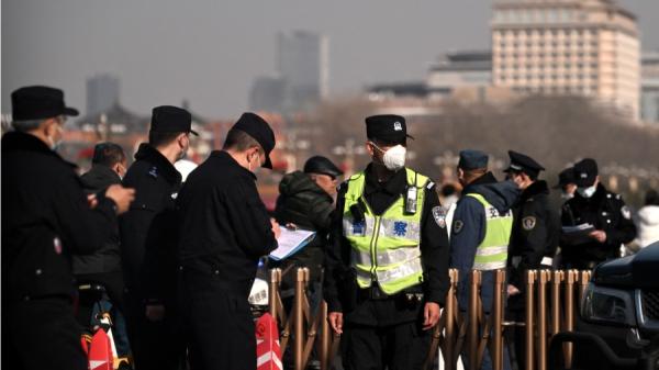 2023年3月2日，北京天安门广场附近，警察在场盘查居民。（图片来源：NOEL CELIS/AFP via Getty Images）