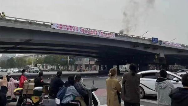 北京四通桥一名男子挂横幅抗议，遭到中共封杀。 （图片来源：网络截图）