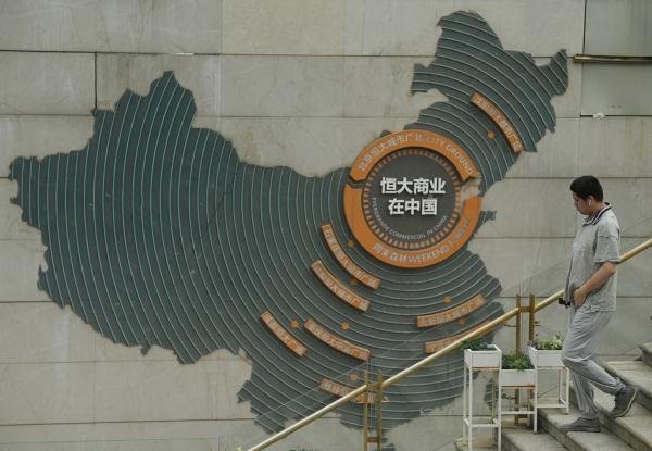 2022年7月28日北京，一名男子走过显示恒大集团在各地业务的标牌。（NOEL CELIS/AFP via Getty Images） 