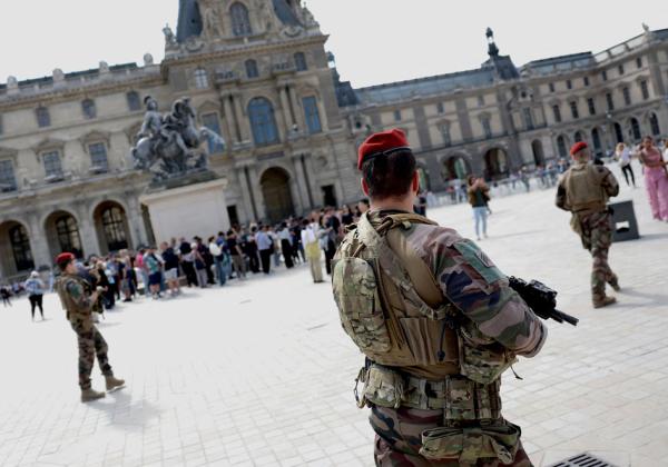 在阿拉斯恐袭事件后，法国反恐安全措施提升到最高警戒状态。图为在巴黎卢浮宫门口的反恐巡逻队。（EMMANUEL DUNAND/AFP via Getty Images）