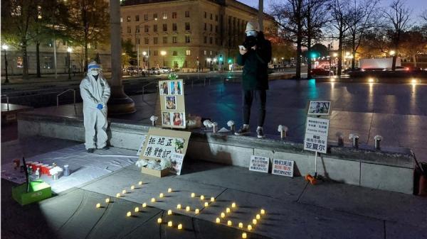 2023年11月125日，在美国首府华盛顿纪念白纸运动现场，十几位与会者围绕烛光进行默哀，并一同诵读诗歌《我们夺回被篡改的记忆》。（图片来源：自由亚洲电台）