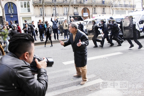 站在亚裔青年和警察之间的华人长者。(摄影:林莲怡、李牧/看中国) 站在亚裔青年和警察之间的华人长者。(摄影:林莲怡、李牧/看中国)