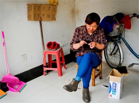 某出租房内，陪读妈妈织毛衣，后边牌子写着警示语。中午妈妈们一声不响，整个小区也安静下来，一切为了孩子休息。（网络图片）