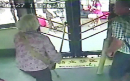 老太太用拐杖砸门。（网络截频）