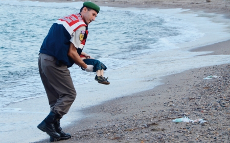 土耳其海岸警察在海滩上将遇难叙利亚幼童抱起。(AFP/Getty Images)