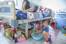 尤恒毅在病房里帮助照顾爸爸,在给爸爸放尿袋。 尤恒毅在病房里帮助照顾爸爸,在给爸爸放尿袋。