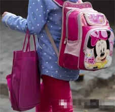 早晨,一个小学生背、挎一大一小两个书包去上学,小书包里是放学后补习班要用的。 早晨,一个小学生背、挎一大一小两个书包去上学,小书包里是放学后补习班要用的。