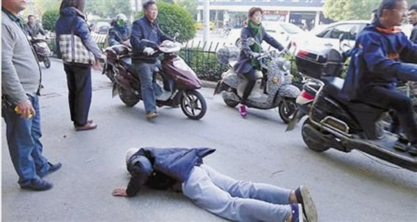 孙女士等人挡在老人身前,以免过往车辆撞到他。(网络图片) 孙女士等人挡在老人身前,以免过往车辆撞到他。(网络图片)