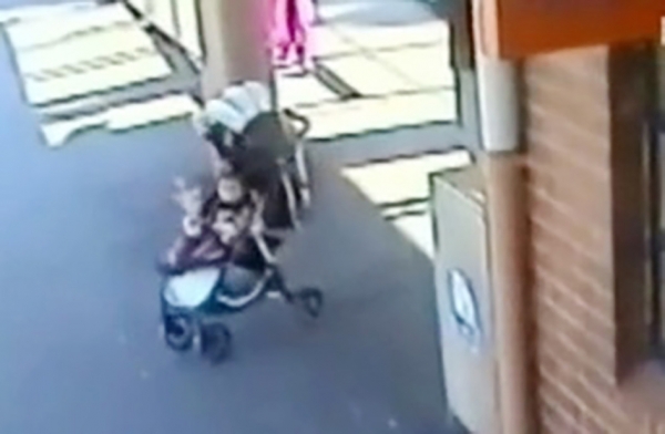婴儿车无人看管，正在滚离火车站月台。（视频截图）