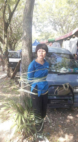 中国女子马来西亚行骗,被当地居民围捕绑树上。(视频截图) 中国女子马来西亚行骗,被当地居民围捕绑树上。(视频截图)