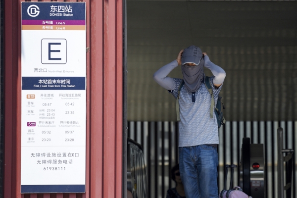 7月12日,北京气温高达35度以上。图为一名男子离开地铁站时,带上太阳面罩以抵挡高温热浪。(Getty Images) 7月12日,北京气温高达35度以上。图为一名男子离开地铁站时,带上太阳面罩以抵挡高温热浪。(Getty Images)