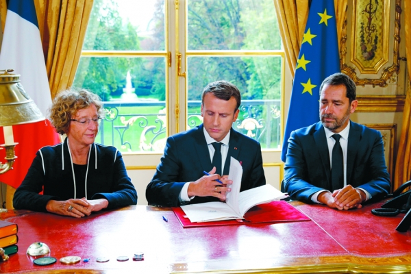 9月22日,马克隆在劳工部长佩尼科(Muriel Pénicaud)(左)和政府发言人卡斯塔纳(Christophe Castaner)(右)陪同下签署劳工法改革法令。(AFP/Getty Images) 9月22日,马克隆在劳工部长佩尼科(Muriel Pénicaud)(左)和政府发言人卡斯塔纳(Christophe Castaner)(右)陪同下签署劳工法改