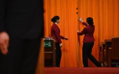 2024年3月5日，在北京人民大会堂举行的全国人民代表大会开幕典礼上，工作人员的在拉上大厅入口处帷幕。（图片来源：Getty Images）