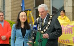 2025年5月6日，加拿大安省阿默斯特堡市（Amherstburg）市长迈克尔．普鲁（右）（Michael Prue）在庆祝第33届世界法轮大法日升旗仪式上发言。（图片来源：NTD）