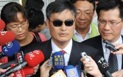 2013年6月25日，流亡台湾的盲人维权人士陈光诚（中）在台北台湾立法院发表备受瞩目的演讲后，与妻子袁维京（左）接受记者采访。超过500名嘉宾挤满了立法院礼堂，热烈欢迎陈光诚的演讲。(Mandy Cheng/AFP via Getty Images）