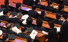 2018年3月19日，在北京人民大会堂举行的第十三届全国人大第七次全体会议投票前，中共军方代表从工作人员手中领取选票。（图片来源：Etienne Oliveau/Getty Images）