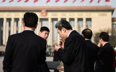 2018年3月19日，在北京人民大会堂举行的第十三届全国人民代表大会第七次全体会议召开前，与会代表们在天安门广场吸烟。（图片来源：Etienne Oliveau/Getty Images）