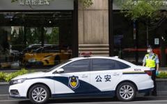 2022年7月1日，一名警察站在上海一家商店前的警车旁。（图片来源：Hugo Hu/Getty Images）