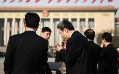 2018年3月19日，在北京人民大会堂举行的第十三届全国人民代表大会第七次全体会议召开前，与会代表们在天安门广场吸烟。（图片来源：Etienne Oliveau/Getty Images）