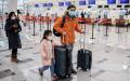 图为1月22日，戴着口罩的一家三口在北京机场。（AFP via Getty Images）