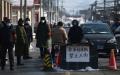 2020年2月7日北京居民站在怀柔区下辖的九渡河镇入口处。（图片来源：GREG BAKER/AFP via Getty Images)