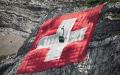 挂在山岩上的巨幅瑞士国旗（FABRICE COFFRINI/AFP via Getty Images）