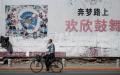 2018年5月29日，辽宁丹东的一位路人骑自行车经过一副中国梦的标语牌。（图片来源：FRED DUFOURAFP via Getty Images）