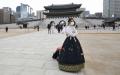 一名身穿韩国传统韩服的女子站立在首尔景福宫前。（JUNG YEON-JE/AFP via Getty Images）