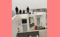 1月10日，陕西西安民工站在楼顶，威胁跳楼讨薪。（图片来源：视频截图）