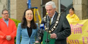 2025年5月6日，加拿大安省阿默斯特堡市（Amherstburg）市长迈克尔．普鲁（右）（Michael Prue）在庆祝第33届世界法轮大法日升旗仪式上发言。（图片来源：NTD）