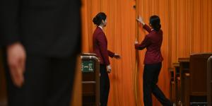 2024年3月5日，在北京人民大会堂举行的中共全国人民代表大会开幕典礼上，工作人员拉住大厅入口处的帷幕。（图片来源：Getty Images）