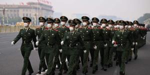 2022年10月1日，中共国殇日当天，在北京天安门广场举行的升旗仪式后，共军列队行进。（图片来源：Getty Images）