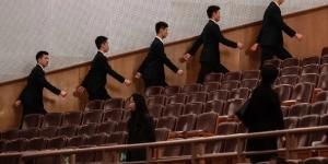 2026年3月12日，中共全国人民代表大会闭幕式开始前，在北京人民大会堂的安保人员走向各自岗位。（图片来源：Kevin Frayer/Getty Images）