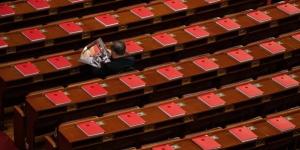 2026年3月12日，在全中共国人民代表大会闭幕式前，一名代表正在北京人民大会堂里阅读关于会议的杂志。（图片来源：Kevin Frayer/Getty Images）