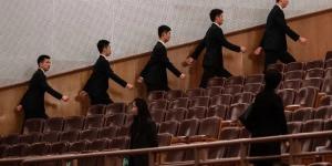 2026年3月12日，中共全国人民代表大会闭幕式开始前，在北京人民大会堂的安保人员走向各自岗位。（图片来源：Kevin Frayer/Getty Images）