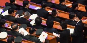 2018年3月19日，在北京人民大会堂举行的第十三届全国人大第七次全体会议投票前，中共军方代表从工作人员手中领取选票。（图片来源：Etienne Oliveau/Getty Images）