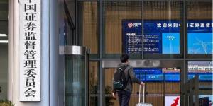 2025年11月12日，一名手提行李箱的男士走进位于北京的中国证券监督管理委员会（证监会）大楼。（图片来源：Cheng Xin/Getty Images）