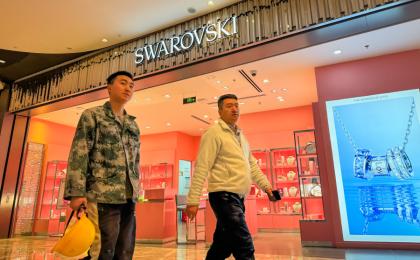 2024 年 11 月 13 日，两名男子走过重庆的一家购物中心的施华洛世奇专卖店。（图片来源：Getty Images）