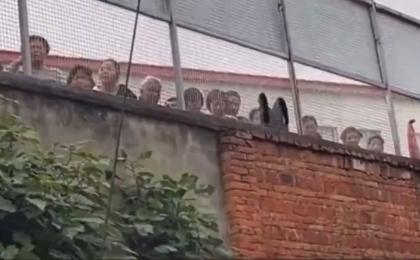 重庆一精神病院多名“病人”在围墙内向路人求救。（图片来源：网路截图）