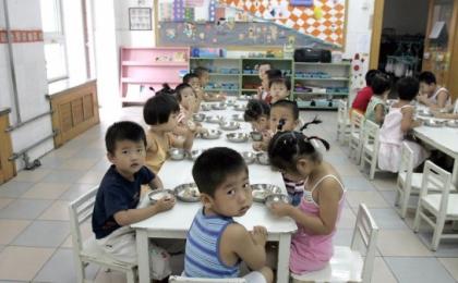 2004年8月5日，学生们在北京的一家幼儿园里享用早餐。（图片来源：GOH Chai Hin/AFP via Getty Images）