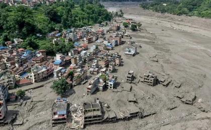 2026年8月26日，尼泊尔努瓦科特地区特里苏里巴扎尔（Trishuli Bazar），突发洪水过后，河岸边的房屋部分浸泡在泥水中。（图片来源Prabin RANABHAT / AFP via Getty Images）