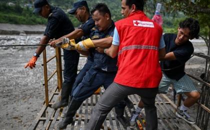 2026年9月4日，山洪暴发后，尼泊尔警察人员在特里舒利河（Trishuli River）两岸拉动临时搭建的手动滑索。（图片来源：Ritesh Shukla/Getty Images）