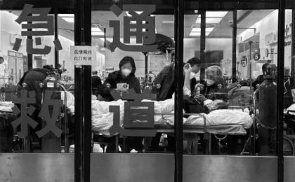 2023年1月14日，上海疫情期间，病人和护理人员站在医院急诊室封闭入口处，急诊室被用作溢流区。示意图(图片来源：Kevin FrayerGetty Images)