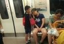 母子乘地铁   小男孩用手为妈妈垫着睡觉