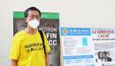 李旭彤博士摄于7月17日法轮功反迫害集会的展板前。